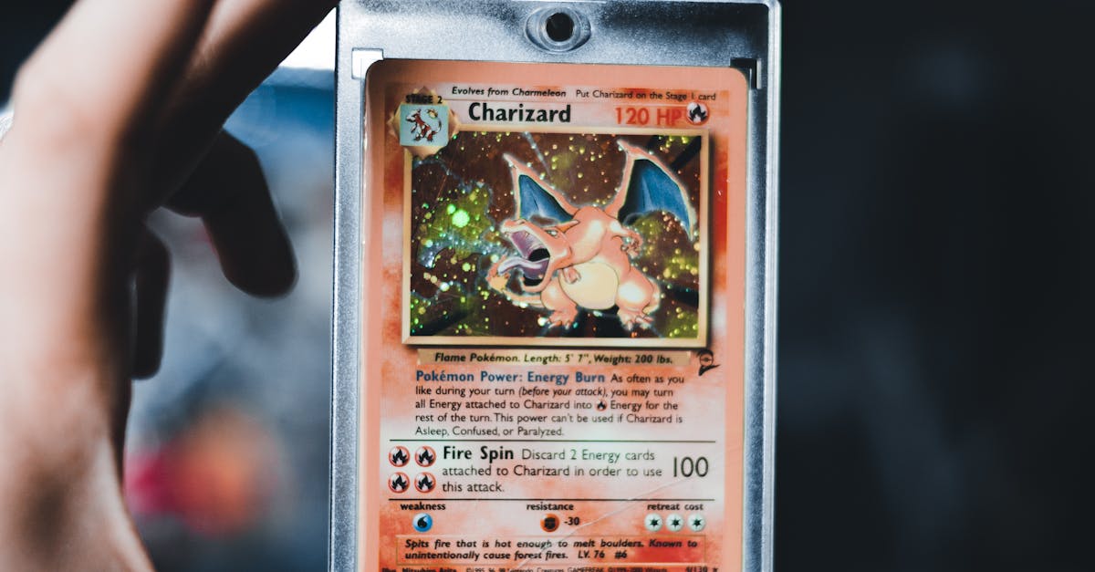 Carte Pokémon Charizard holographique dans une boîte, près d’une main, sur fond sombre.