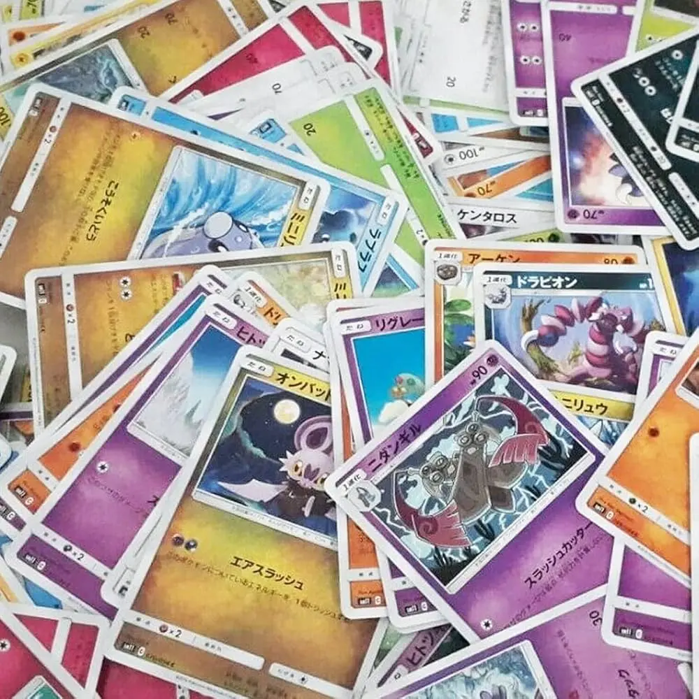 Carte à collectionner jouée en tas, featuring des Pokémon et autres TCG japonais avec des cadres colorés et textes japonais.
